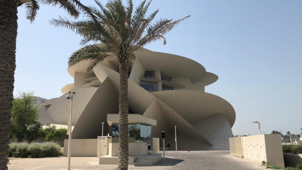 Edifício do Museu Nacional do Qatar e a sua respetiva entrada com uma palmeira.