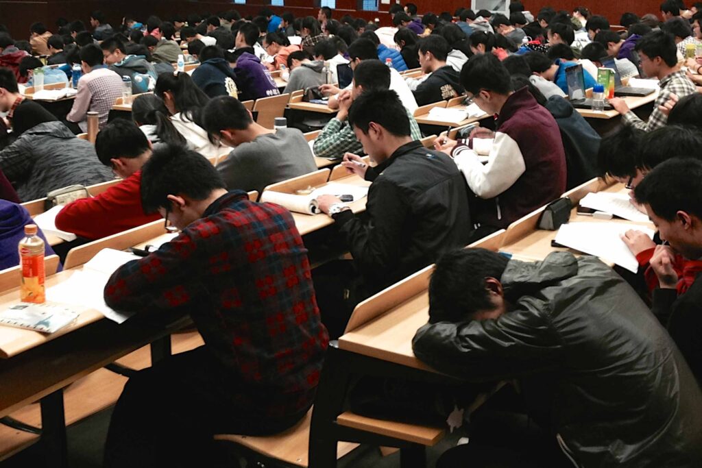 Auditório de uma universidade, com alunos sentados em todos os lugares.