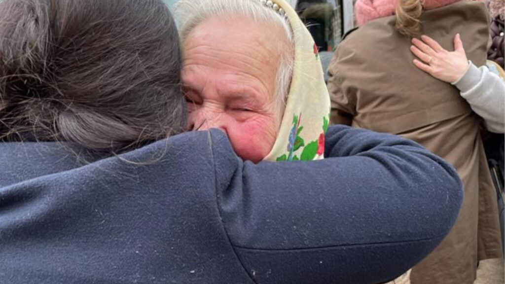 Mulher a abraçar idosa que se mostra muito emocionada