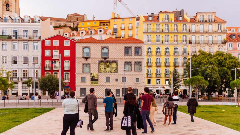 Grupo de turistas de pé em frente à Casa dos Bicos na baixa de Lisboa
