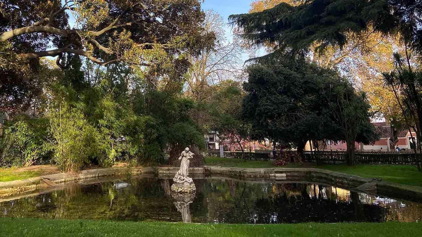 Árvores e lago com estátua no centro