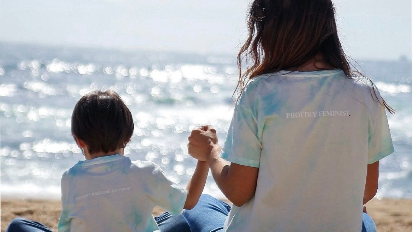 Mãe e filho com t-shirts da marca Peryod na praia