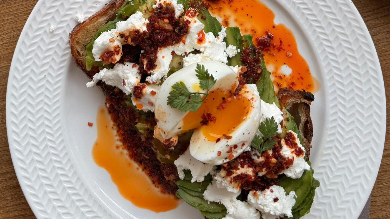 Prato com pão torrado e, por cima, requeijão, abacate e ovo cozido