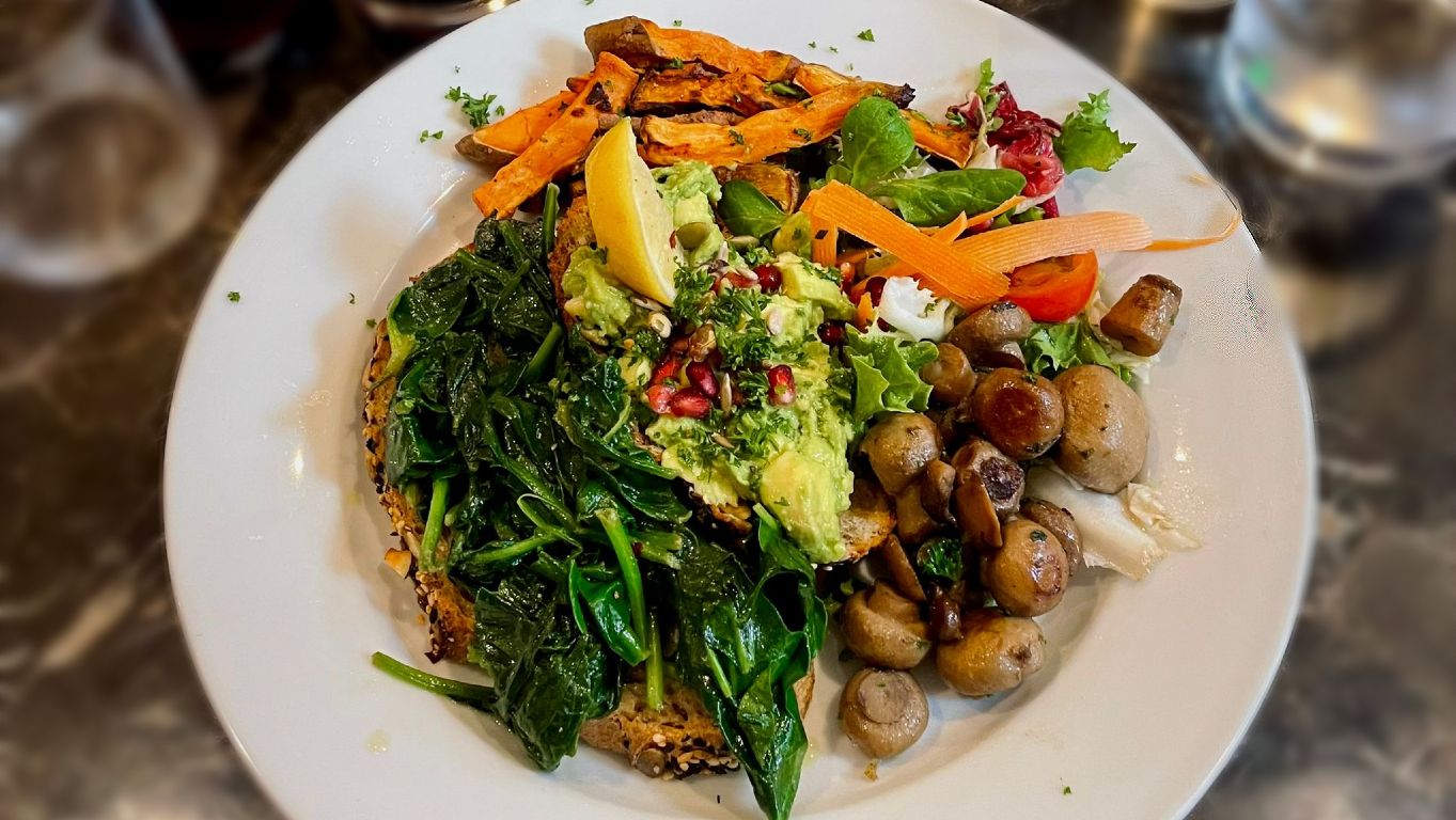 Prato que realça a cor verde, e com bastantes legumes: cogumelos, alface, espinafre, tomate e batata doce, acompanhado de pão