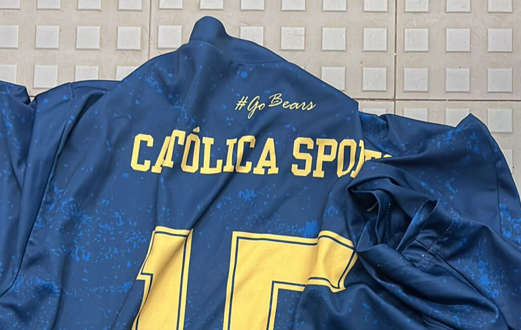 Camisola azul e amarela da Católica Sports com o número 15 e a inscrição #GoBears.