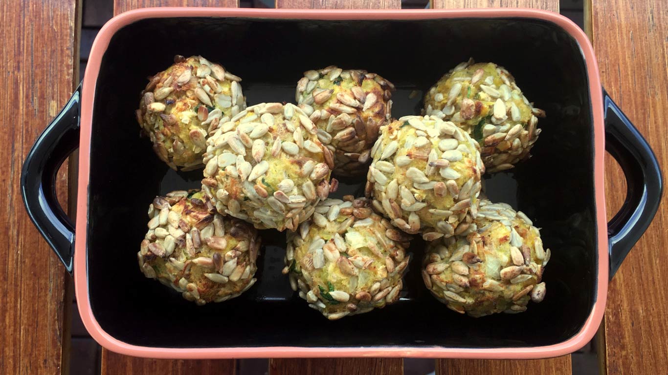 Tabuleiro de oito bolinhas de batata doce com atum, cobertas com sementes de sêsamo.