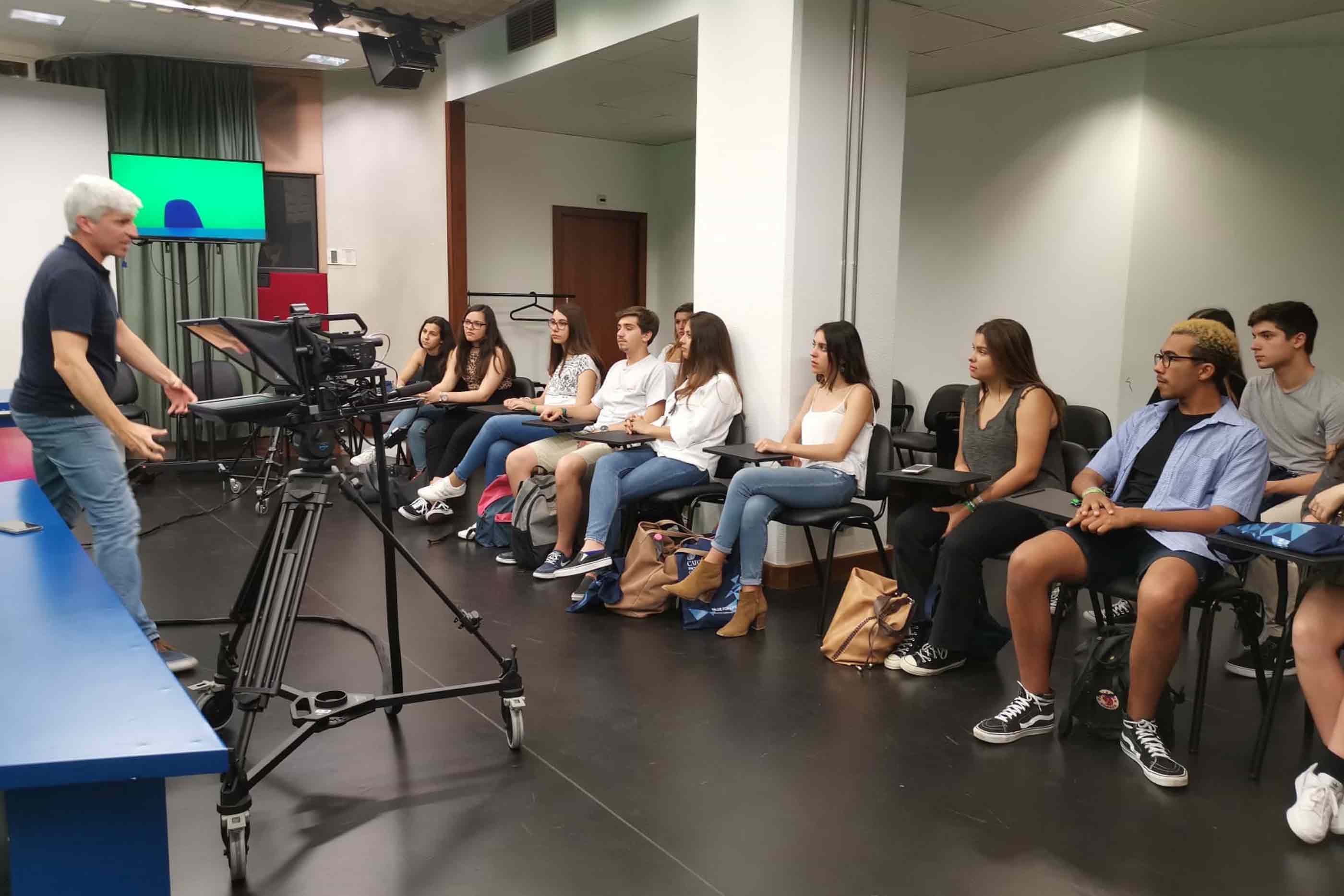 Alunos participam no workshop de televisão, realizado no estúdio da faculdade.