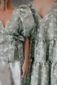 Dois corpos femininos a vestir respetivamente uma camisa e um vestido com o mesmo padrão