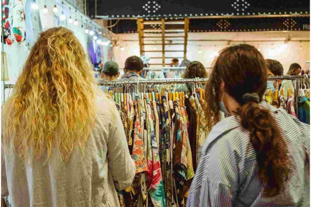 Pessoas a comprar roupa em 2ªmão numa feira
