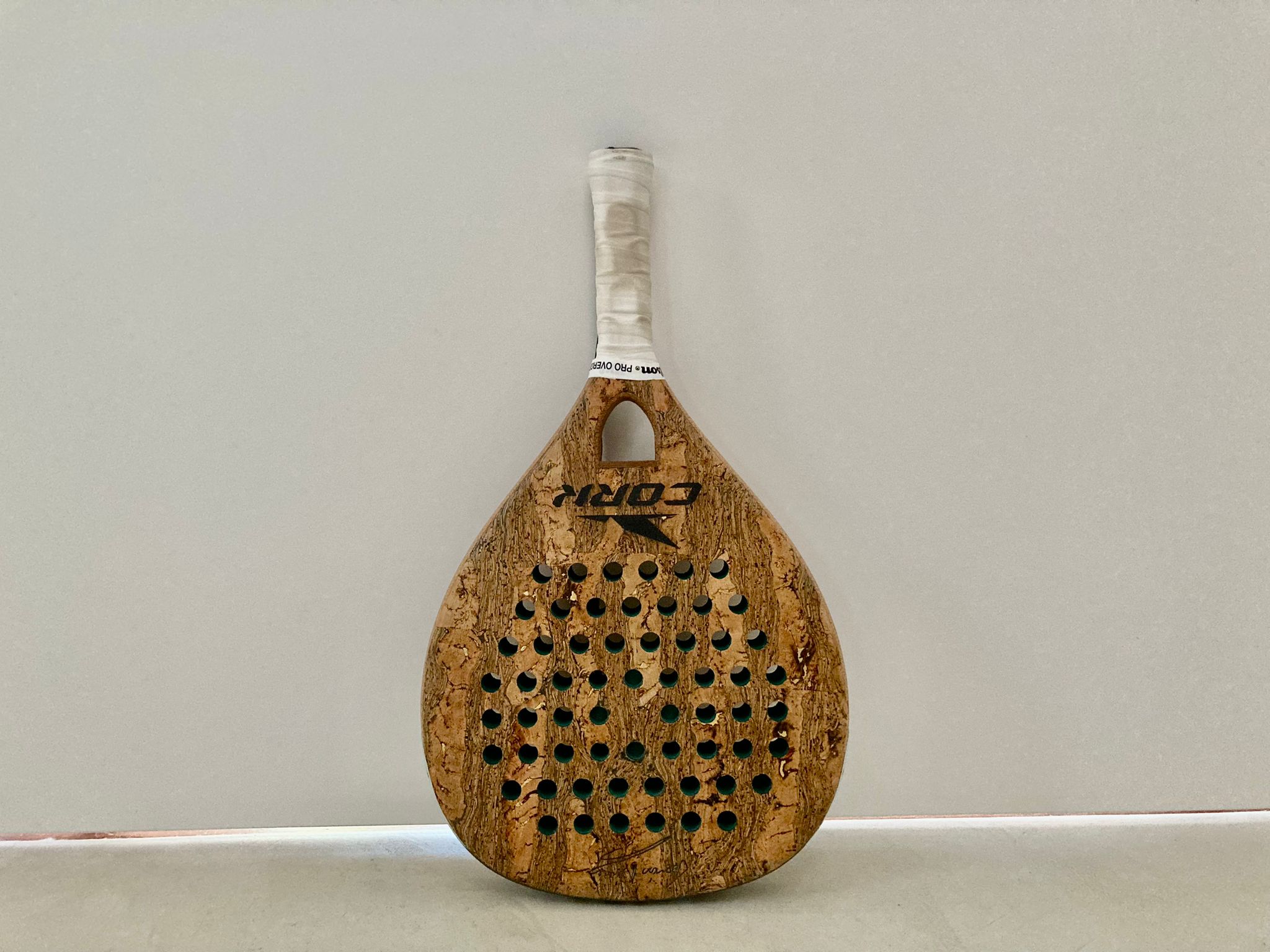 Uma raquete de padel da marca portuguesa "Cork", feita de cortiça.